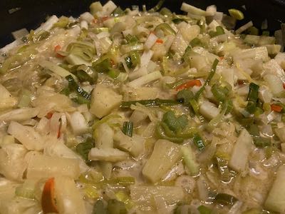 Grünes Thai-Curry mit Kohlrabi, Sellerie und Ananas in der Pfanne