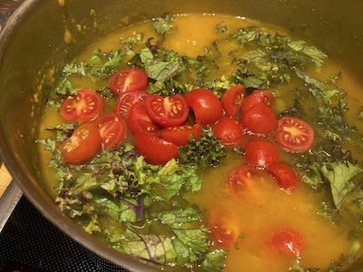Kürbissuppe mit Grünkohl und Cocktail-Tomaten im Topf